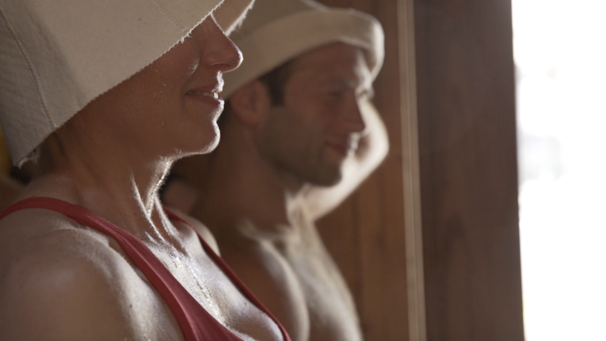 two people in the sauna wearing hats