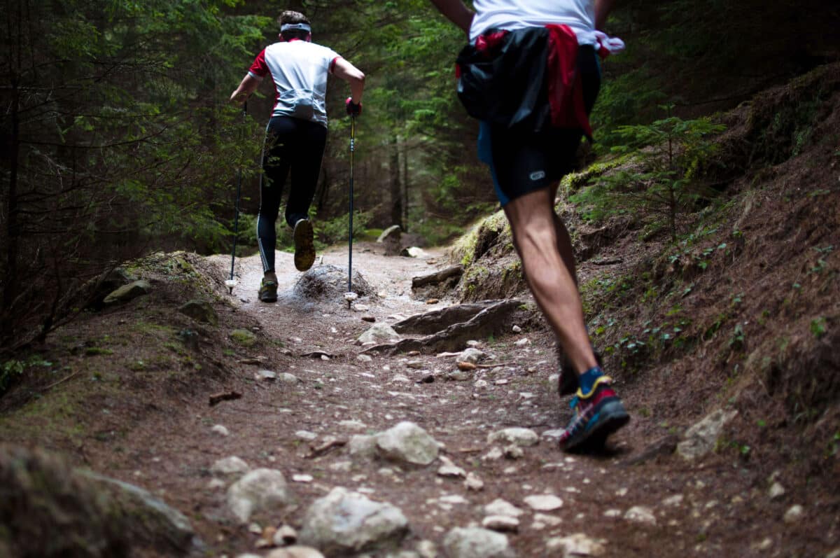 two men trail running in a forest